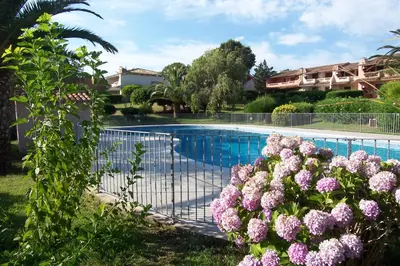 a fence with pink flowers next to a swimming pool at ORO 53 in Conca