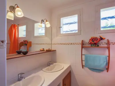 a bathroom with two sinks and two windows at Cosy Holiday Home in Cargèse Corse-du-Sud near Sea in Cargèse