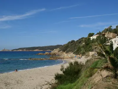 a beach with people sitting on the sand and the water at Cosy Holiday Home in Cargèse Corse-du-Sud near Sea in Cargèse
