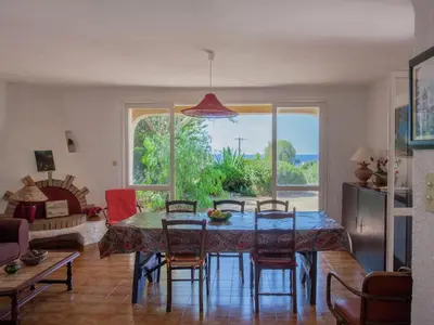 a living room with a dining room table and chairs at Cosy Holiday Home in Cargèse Corse-du-Sud near Sea in Cargèse