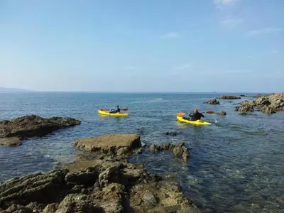 two people in kayaks in the water near the rocks at Cosy Holiday Home in Cargèse Corse-du-Sud near Sea in Cargèse