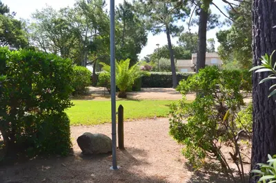 a pole in a garden with a rock and trees at St CYPRIEN C20 in San Ciprianu