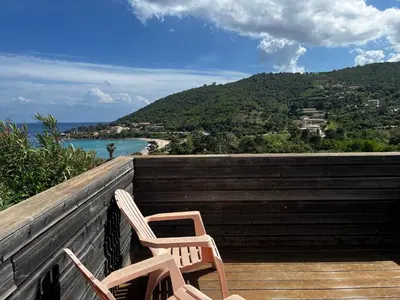 two chairs sitting on a deck with a view of the ocean at ELENA in Conca