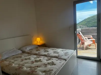 a bedroom with a bed and a balcony with a chair at ELENA in Conca