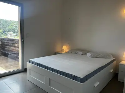 a white bedroom with a bed and a large window at ELENA in Conca
