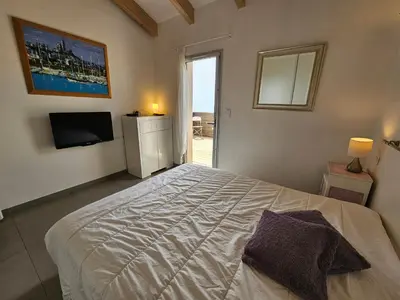 a bedroom with a white bed and a television at SERENA-Piscine privée- Vue Mer in Conca