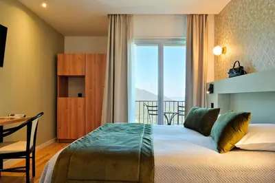 a bedroom with a bed and a window with a view at Hotel Des Roches in Sartène