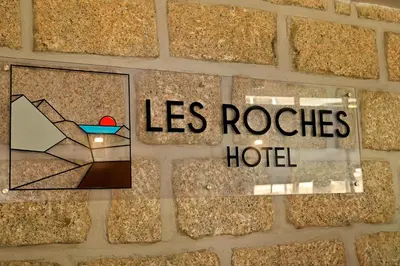 a sign that says las roosters hotel on a wall at Hotel Des Roches in Sartène