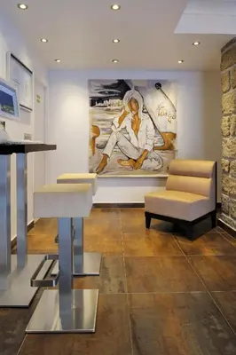 a living room with a painting of a baseball player at Hotel Des Roches in Sartène