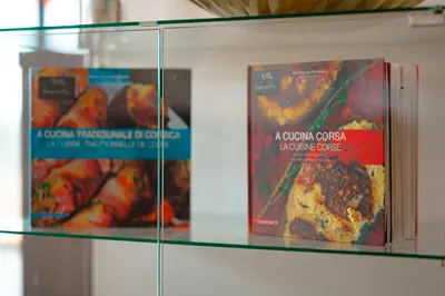 two books sitting on a glass shelf with food at Villa à l'entrée de Porticcio - Piscine - Vue dégagée in Cauro