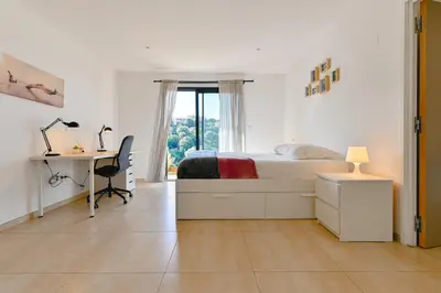 a white bedroom with a bed and a desk and a window at Villa à l'entrée de Porticcio - Piscine - Vue dégagée in Cauro