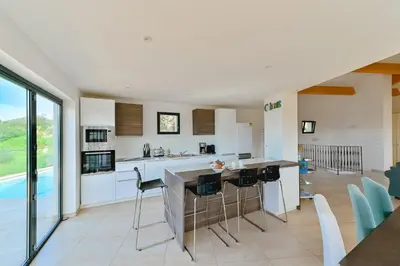a kitchen with a table and chairs in a room at Villa à l'entrée de Porticcio - Piscine - Vue dégagée in Cauro