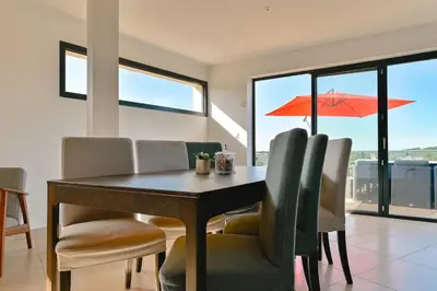 a dining room with a table and chairs and an orange umbrella at Villa à l'entrée de Porticcio - Piscine - Vue dégagée in Cauro