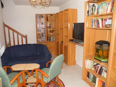 a living room with a blue couch and a table and chairs at Villa Liamone in Sagone