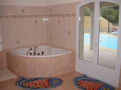 a bath tub in a bathroom with a pool at Villa Liamone in Sagone