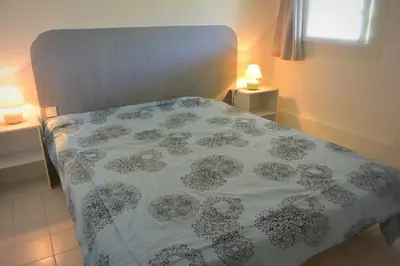 a bed with a flowered bedspread on it with two lamps at St CYPRIEN D23 in Porto-Vecchio