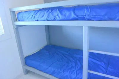 a bunk bed with blue sheets on the bottom bunk at St CYPRIEN D23 in Porto-Vecchio