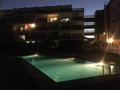 a swimming pool in front of a building at night at Studio standing Piscine vue mer in Porto-Vecchio