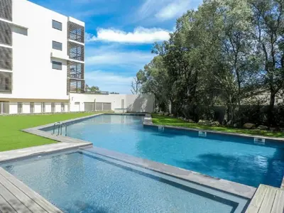 a large swimming pool in front of a building at Studio standing Piscine vue mer in Porto-Vecchio