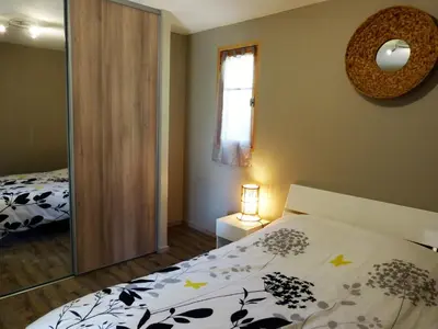 a bedroom with a bed and a mirror at Magnifique chalet vue mer, a quelques minutes des plages in Olmeto