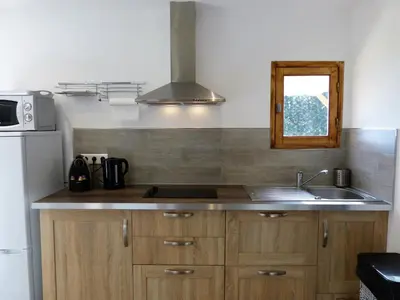 a kitchen with wooden cabinets and a sink and a window at Magnifique chalet vue mer, a quelques minutes des plages in Olmeto