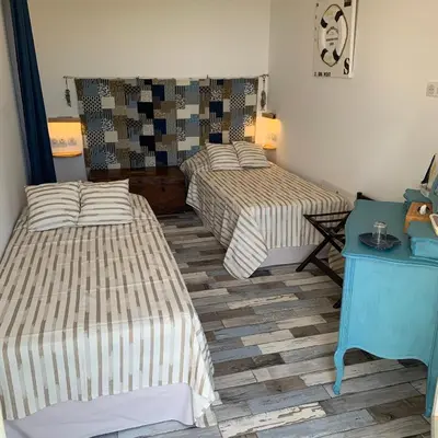 a room with two beds and a blue table at Maison & Piscine Privée Vue Mer panoramique très calme indépendant in Porto-Vecchio