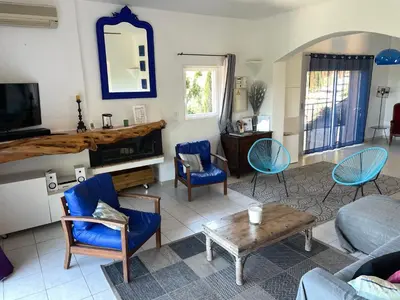 a living room with blue chairs and a couch at Maison & Piscine Privée Vue Mer panoramique très calme indépendant in Porto-Vecchio