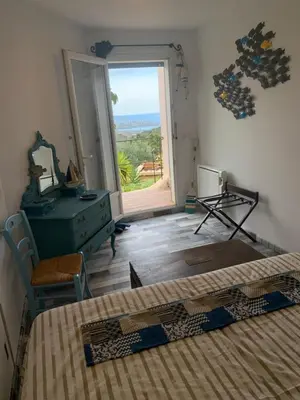 a bedroom with two beds and a window with a view at Maison & Piscine Privée Vue Mer panoramique très calme indépendant in Porto-Vecchio