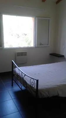 a bed in a room with a large window at Casapiana 08 in Porto-Vecchio