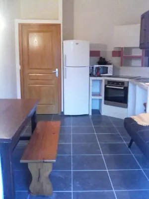 a kitchen with a refrigerator and a table in it at Casapiana 08 in Porto-Vecchio