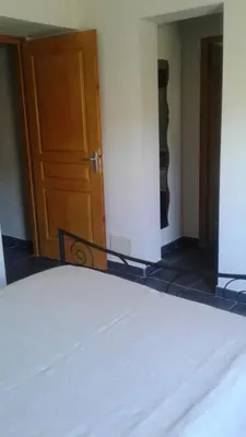 a bedroom with a bed and a wooden door at Casapiana 08 in Porto-Vecchio