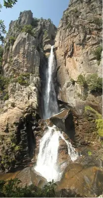 a waterfall on the side of a rocky mountain at Casapiana 08 in Porto-Vecchio