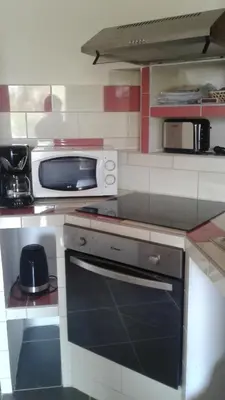 a kitchen with a stove and a microwave at Casapiana 08 in Porto-Vecchio