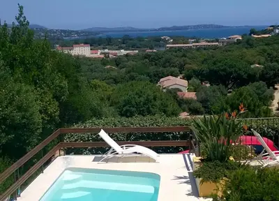 a view of a swimming pool with a chair and a swimming pool at Villa Jeromine in Porto-Vecchio