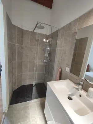 a bathroom with a shower and a white sink at Villa Jeromine in Porto-Vecchio