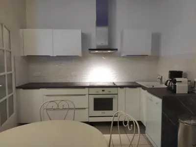 a kitchen with white cabinets and a stove top oven at Villa Jeromine in Porto-Vecchio