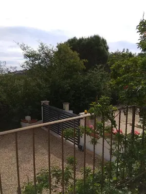 a fence in front of a garden with trees at Villa Jeromine in Porto-Vecchio