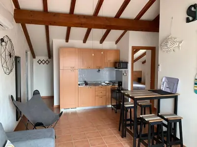 a kitchen and dining room with a table and chairs at Les pieds dans l'eau en Corse ! in Moriani Plage