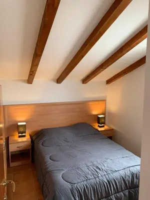 a bed in a room with two lamps on tables at Les pieds dans l'eau en Corse ! in Moriani Plage