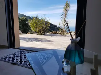 a vase sitting on a table in front of a door at Résidence Le Bella Vista in Piana