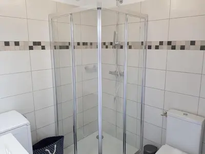 a glass shower in a bathroom with a toilet at Résidence Le Bella Vista in Piana