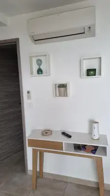a white wall with a wooden table in a room at Résidence Le Bella Vista in Piana