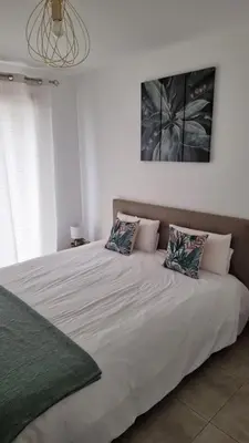 a large white bed with two pillows on it at Résidence Le Bella Vista in Piana