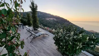 a bench sitting on a patio overlooking the water at Résidence Le Bella Vista in Piana