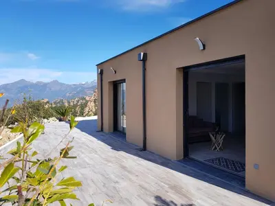 a house with a large glass door on a patio at Résidence Le Bella Vista in Piana