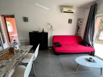 a living room with a red couch and a table at residence Catalani in Zonza