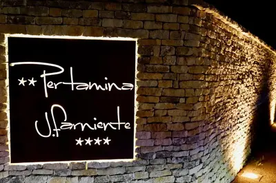 a brick wall with a sign that says performing adventure at Les Suites De Pertamina in Bonifacio