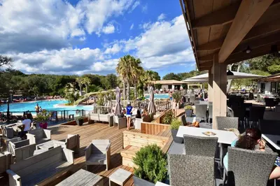 a restaurant with a view of the pool at a resort at Les Suites De Pertamina in Bonifacio