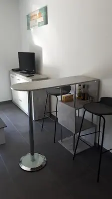 a desk with two chairs and a computer on it at charmant studio dans résidence neuve et calme in Corte