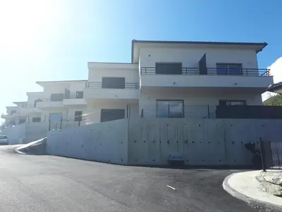 a white building with a fence in front of it at charmant studio dans résidence neuve et calme in Corte